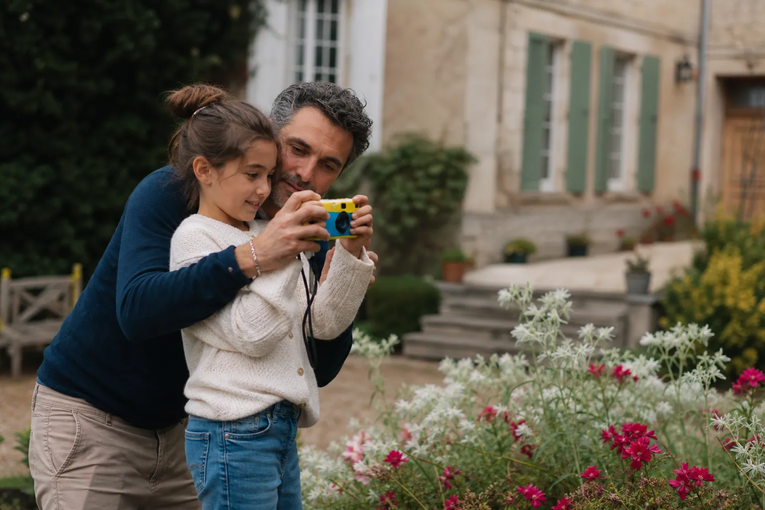 Parent et enfant choisissant un appareil photo dans un jardin lumineux