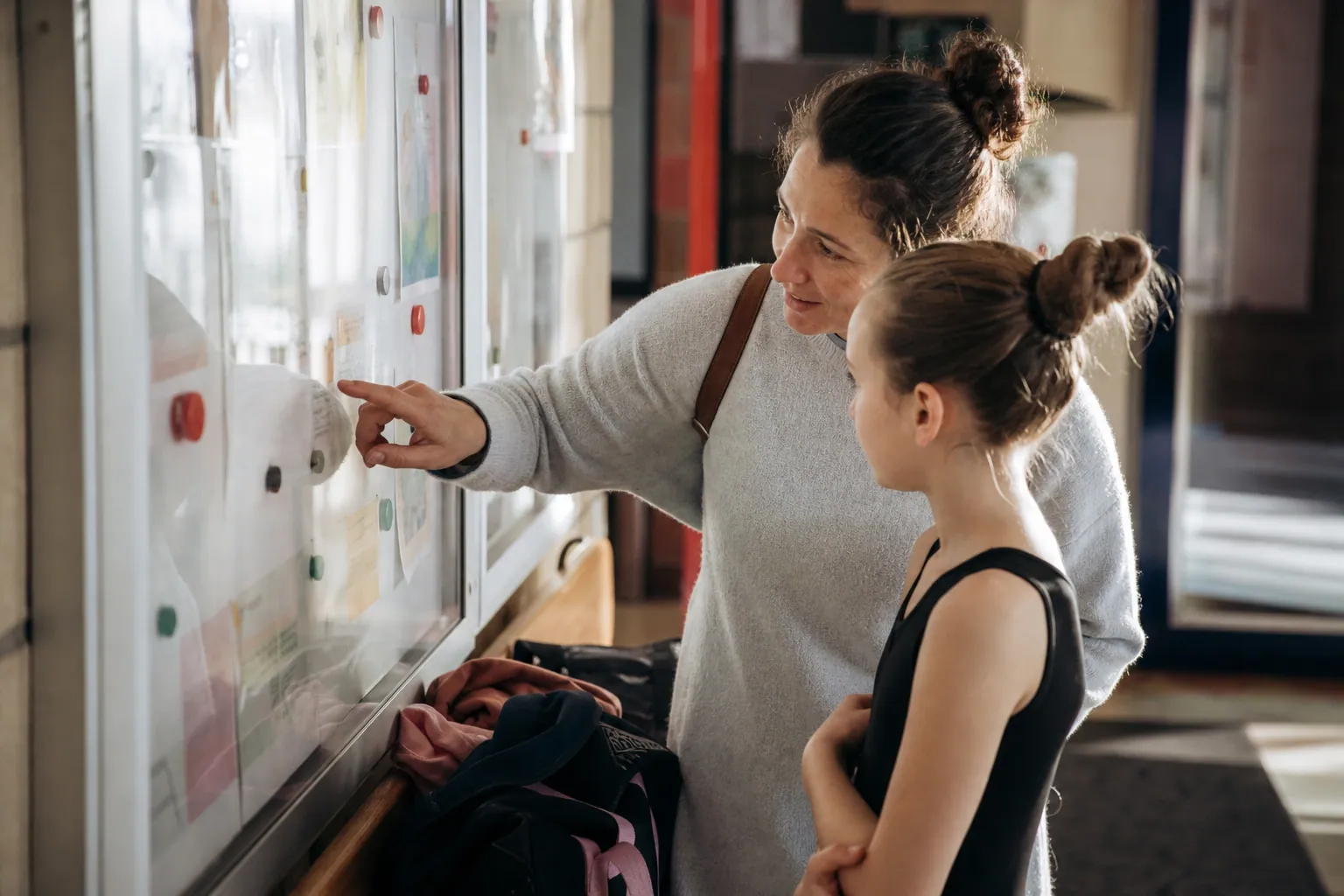 Parent et enfant hésitant entre plusieurs activités extra-scolaires dans un centre de quartier