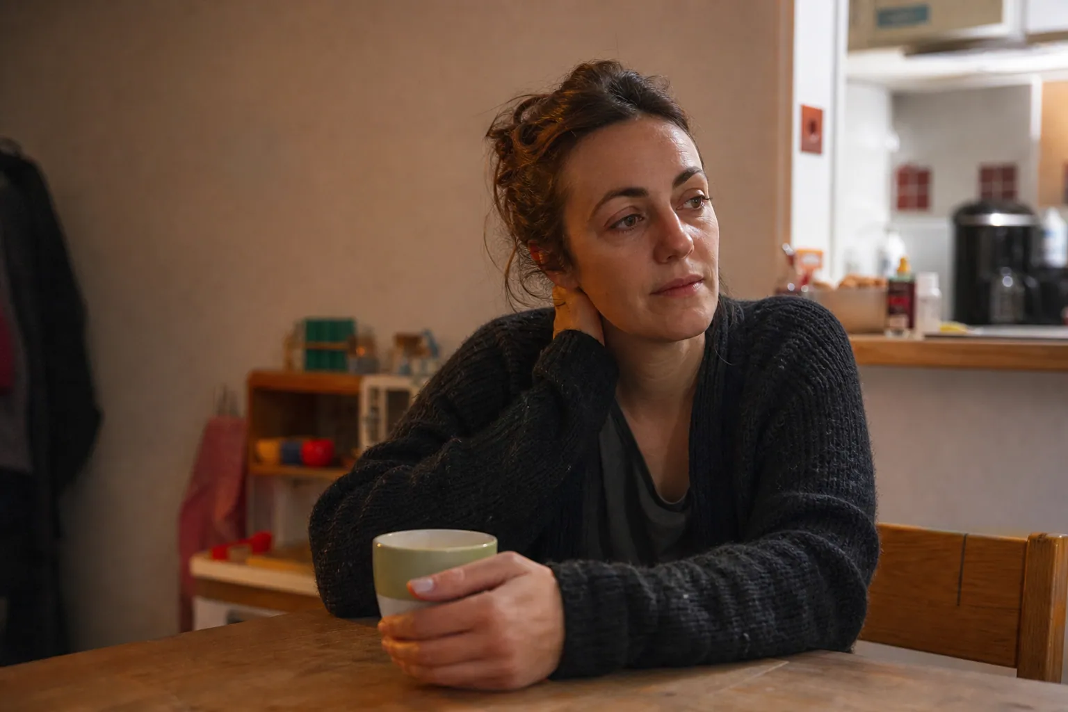 Parent français détendu autour d’un thé, dans une cuisine familiale chaleureuse
