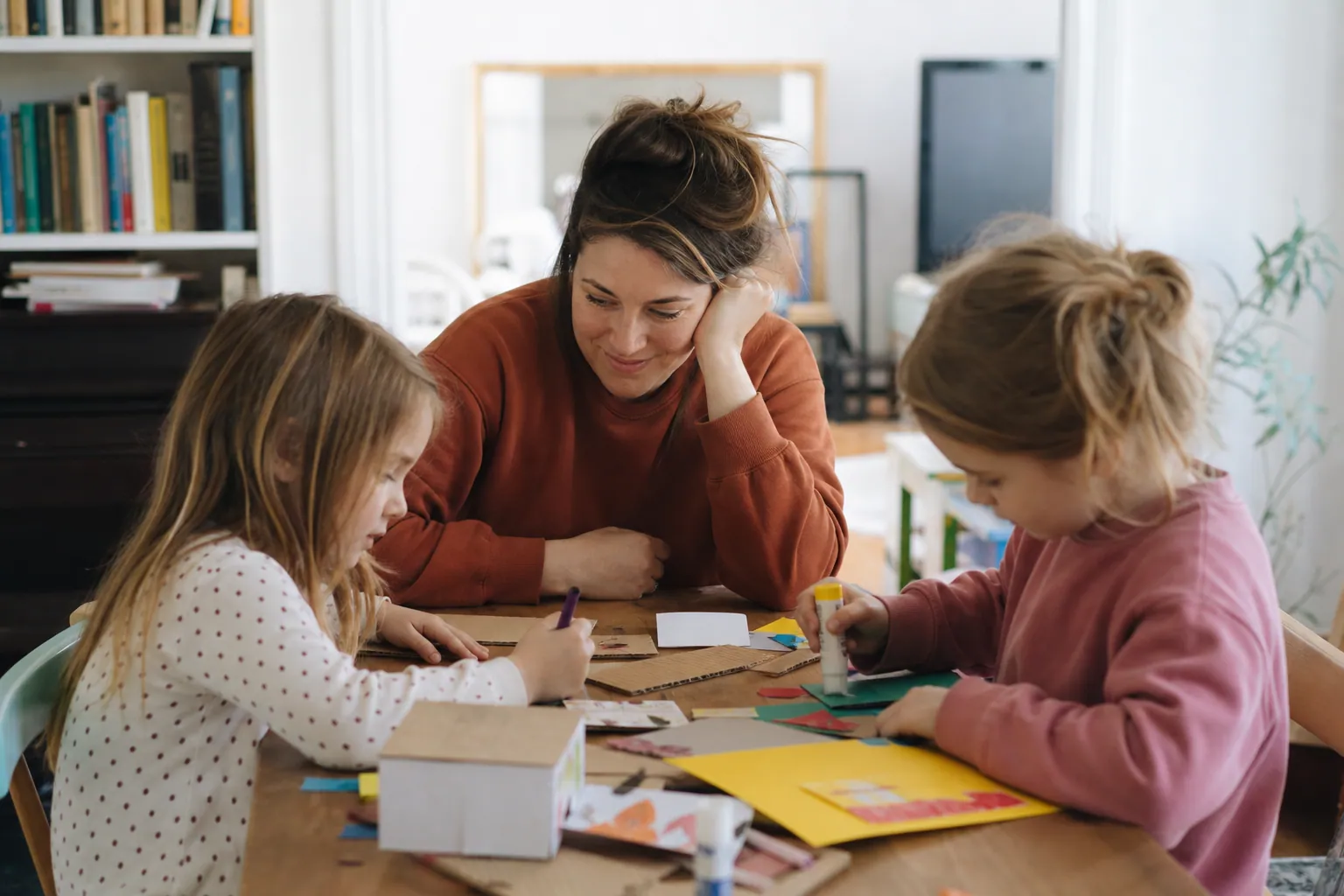Parent et enfants fabriquant un bricolage créatif à la maison