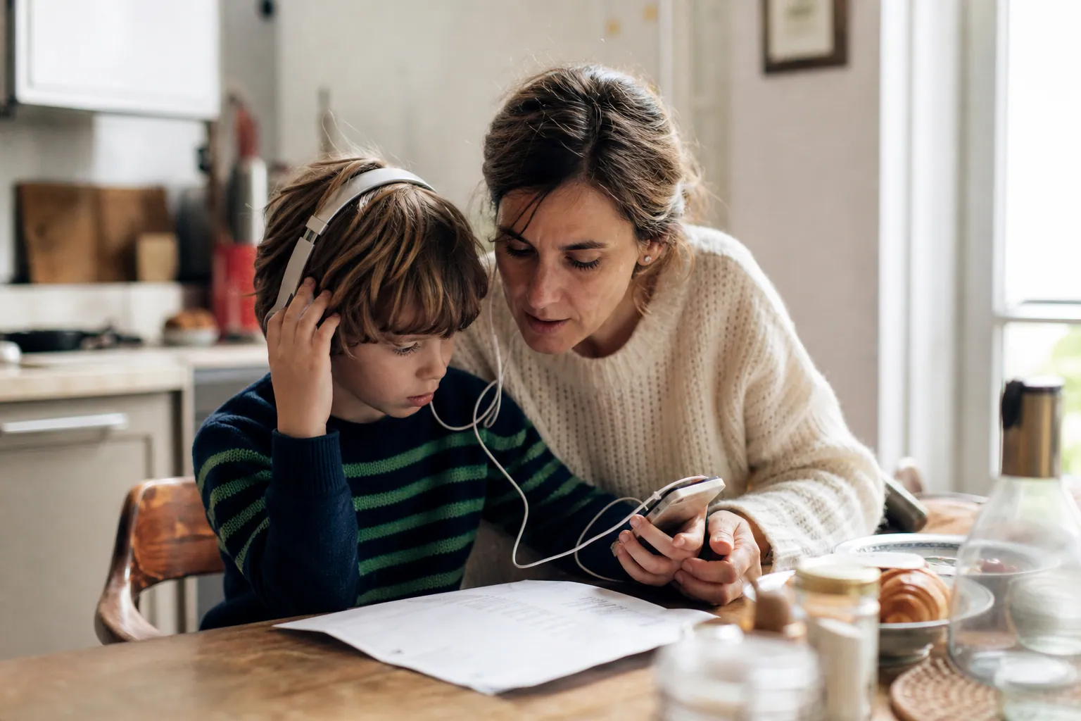 Parent expliquant les paroles d’une chanson à son enfant autour d’une table.