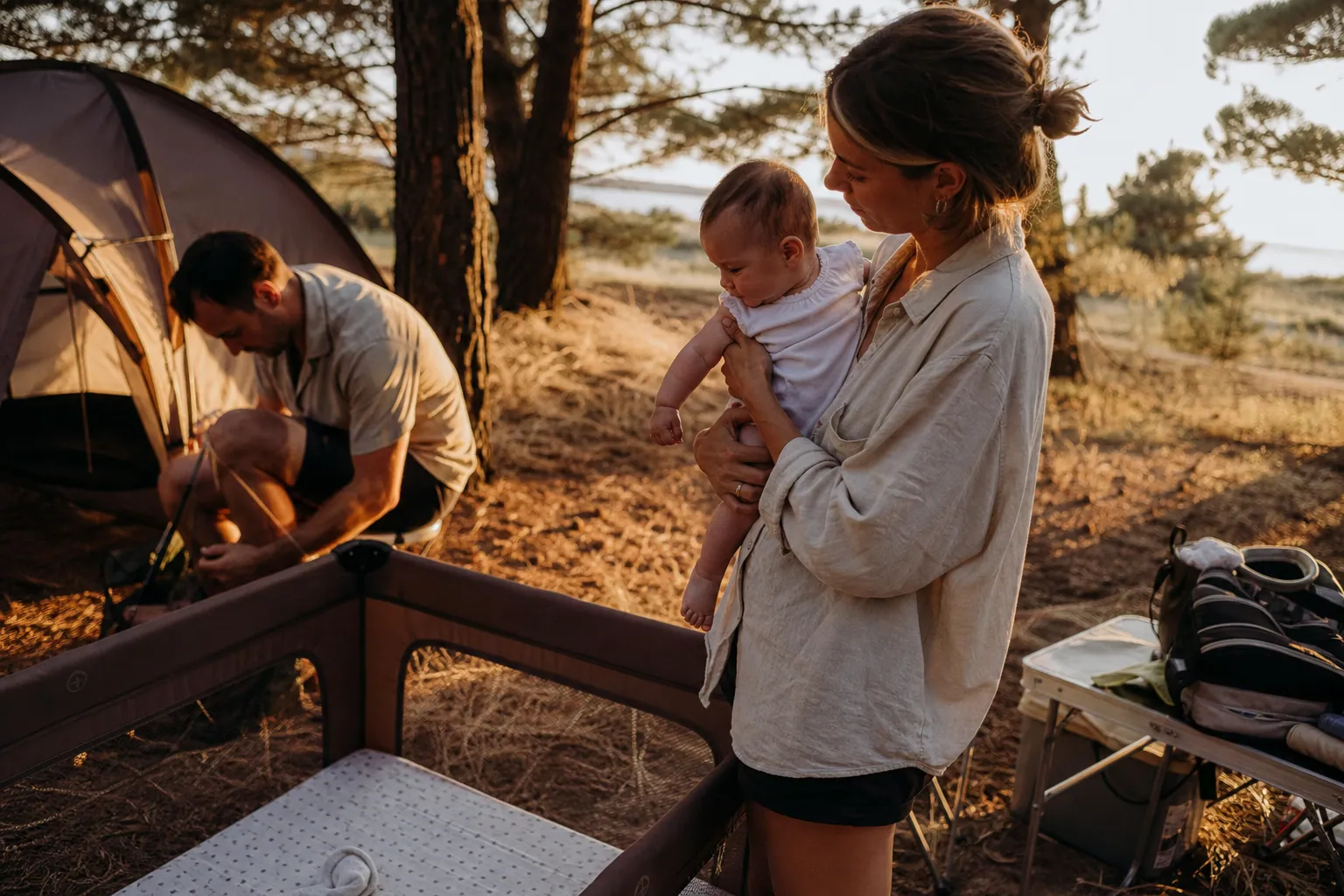 Parents français installant un camping avec leur bébé près d’une tente