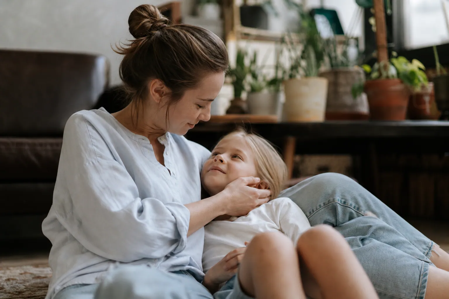 Parent et adolescent échangeant calmement à la maison dans une ambiance chaleureuse.