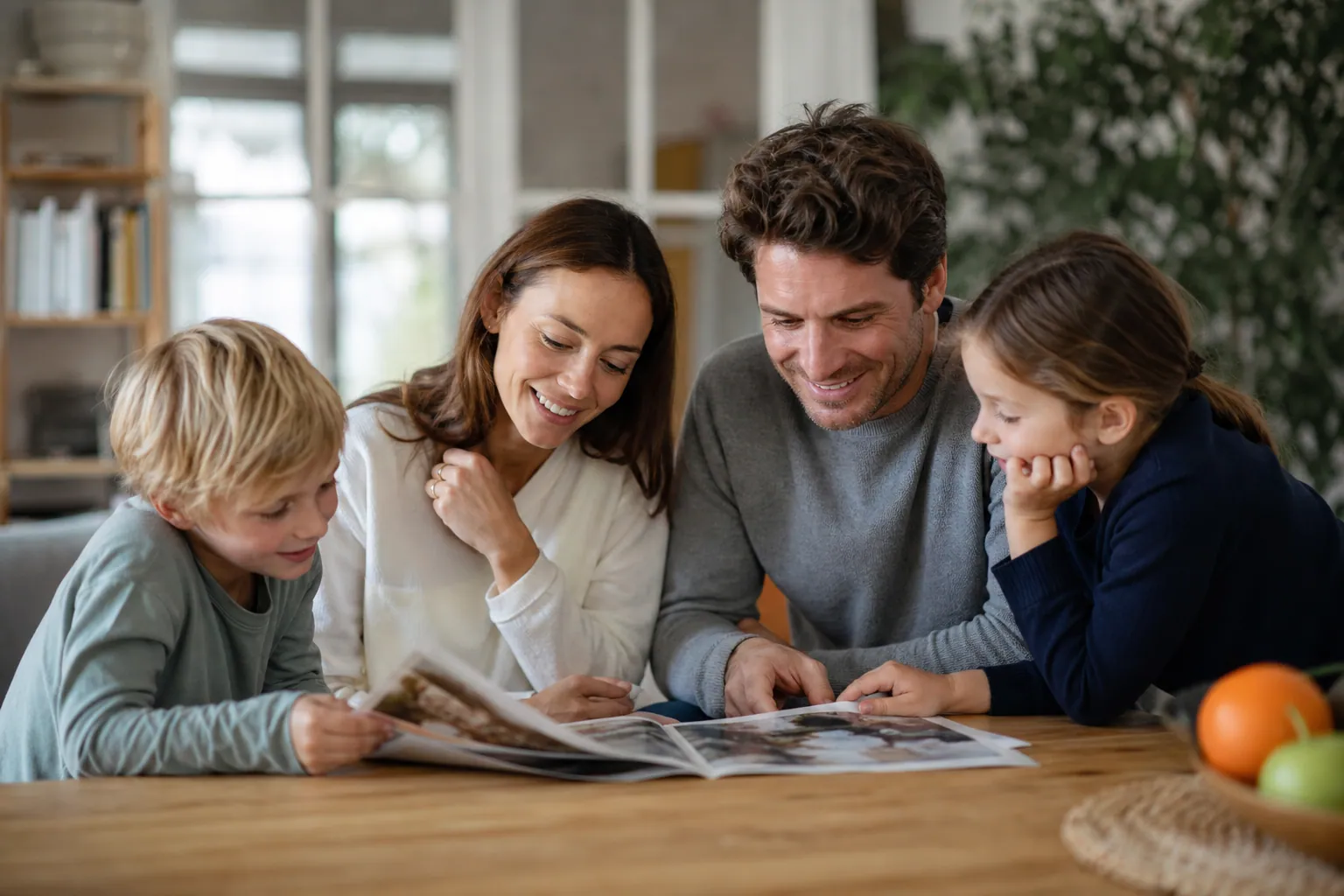 Parents et enfants lisant un magazine familial ensemble à la maison