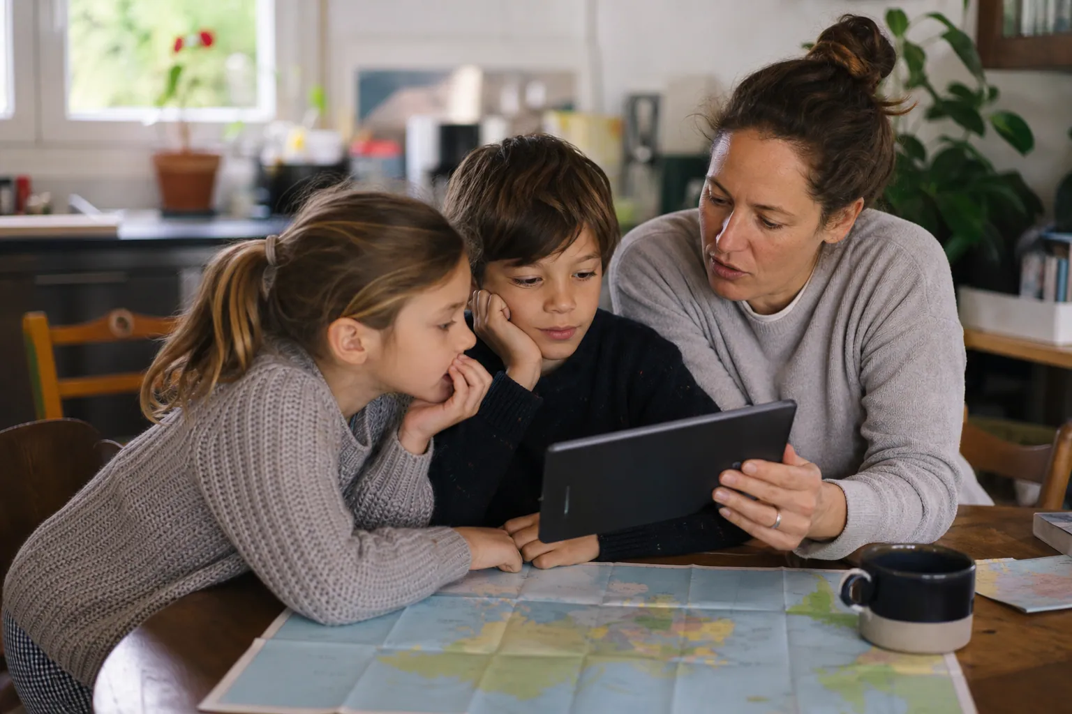 Parent discutant de l’actualité mondiale avec deux enfants autour d’une table