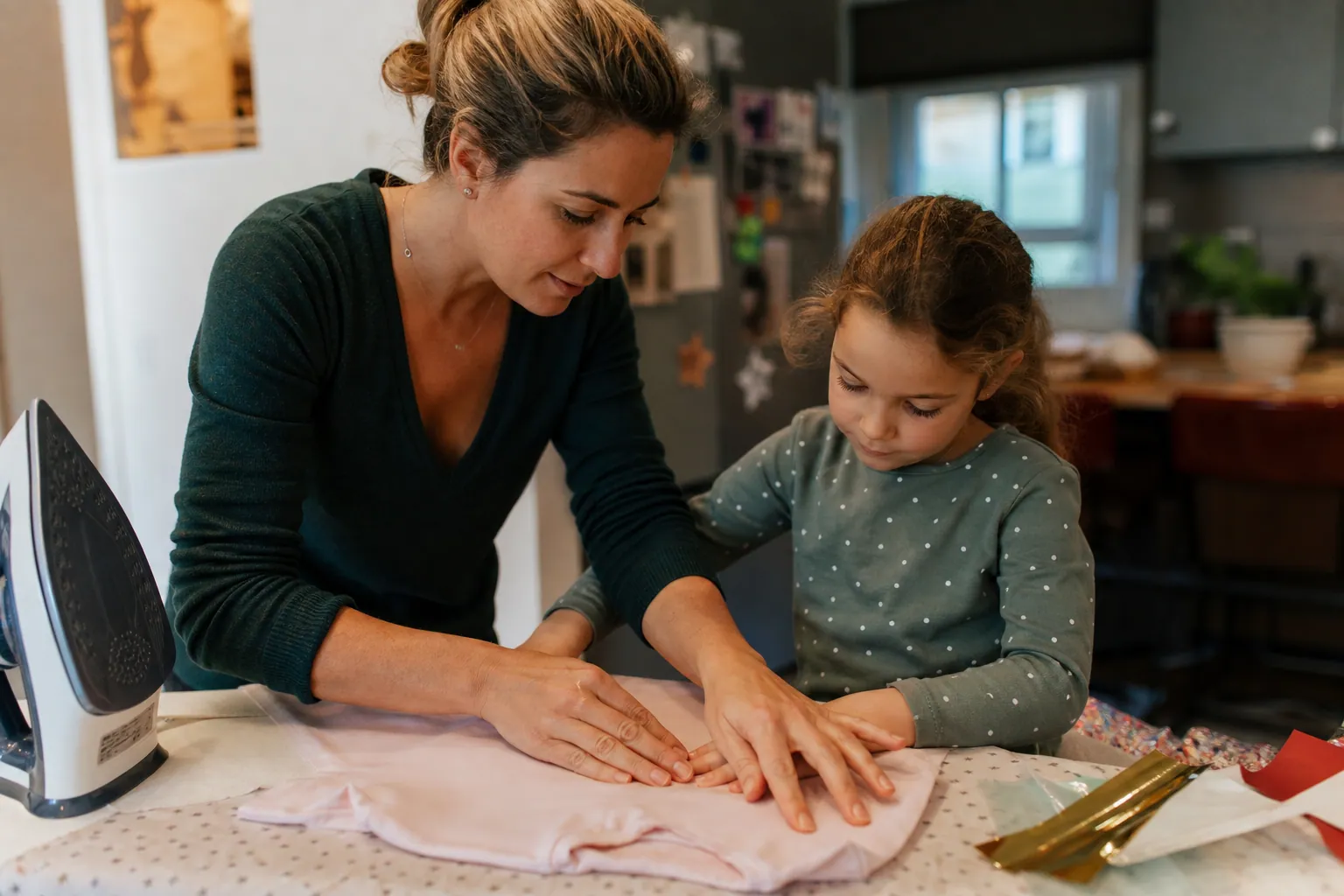 Parent aidant un enfant à plastifier un tissu avec un film thermocollant