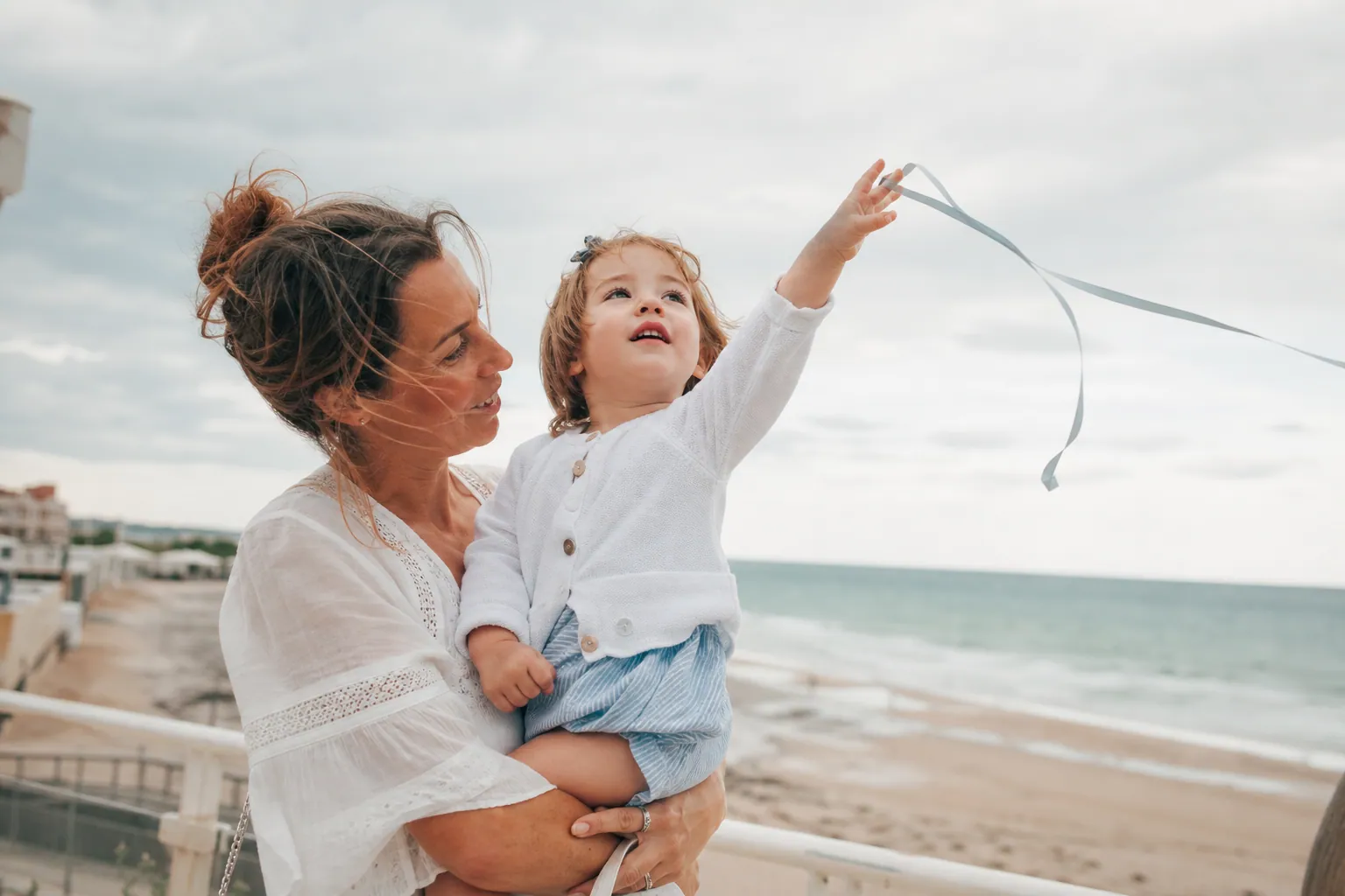 Parent et enfant observant le vent avec un ruban dehors