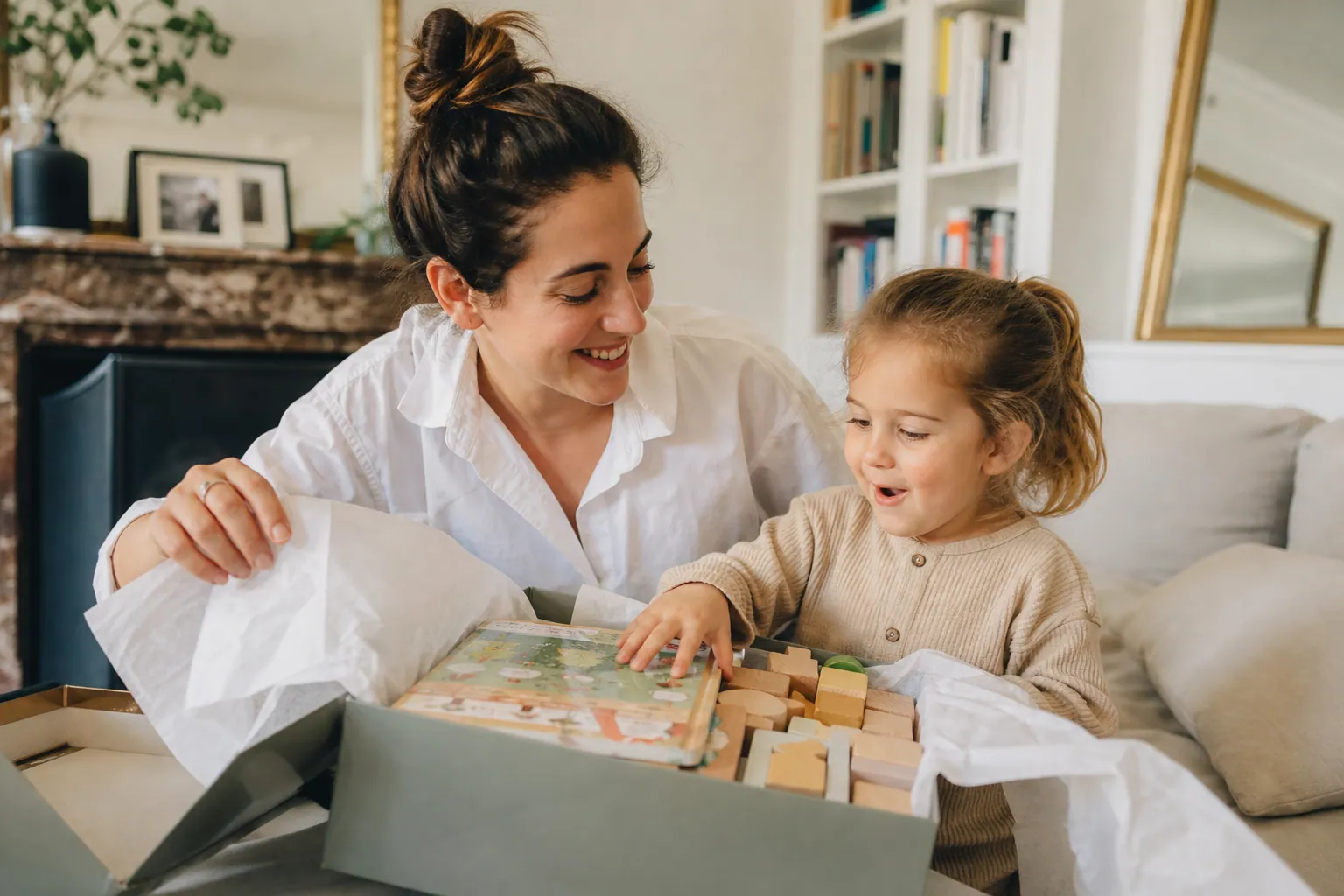 Parent et enfant découvrant ensemble un jeu éducatif à la maison