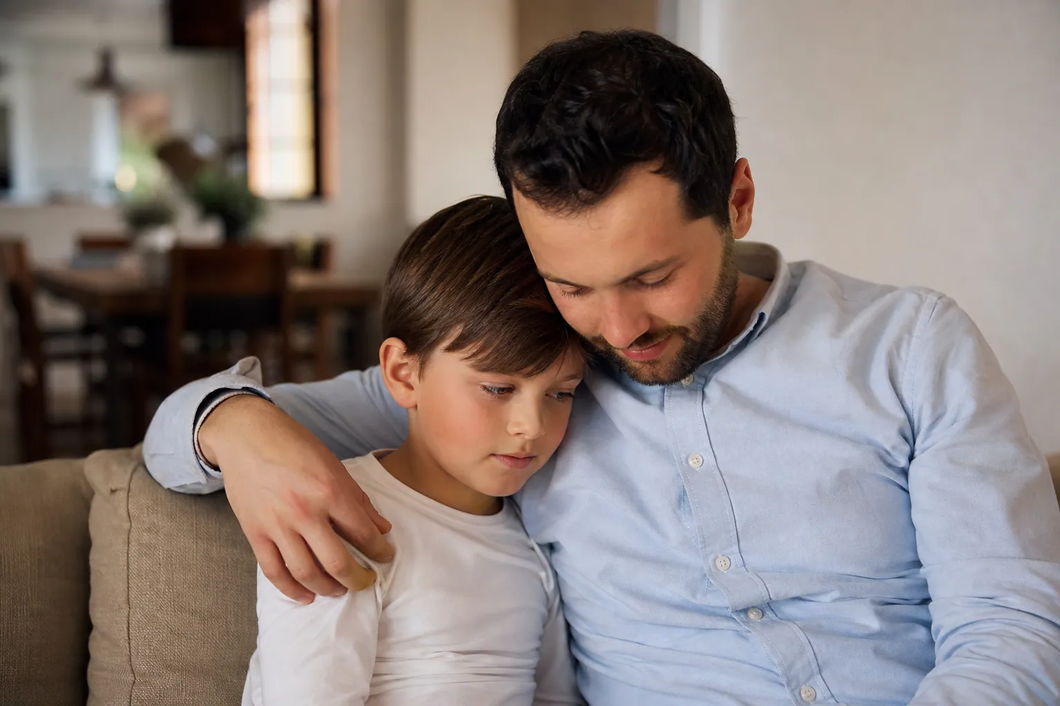 Parent rassurant un adolescent inquiet devant son téléphone à la maison.
