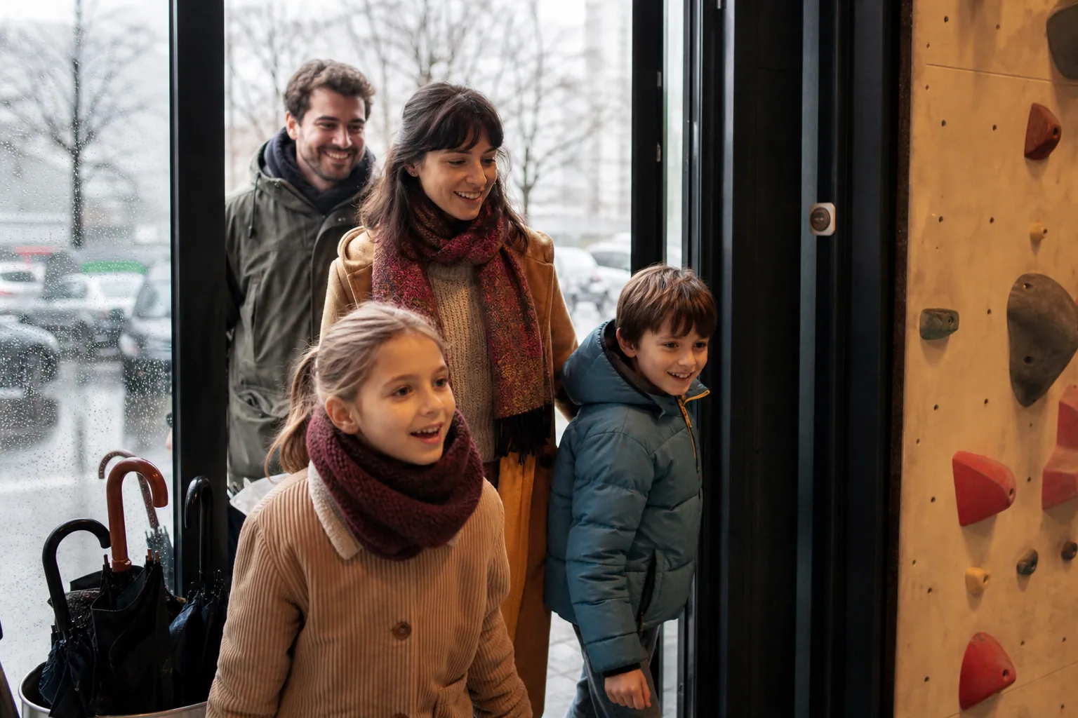 Famille avec deux enfants entrant au sec dans un lieu couvert à Grenoble sous la pluie
