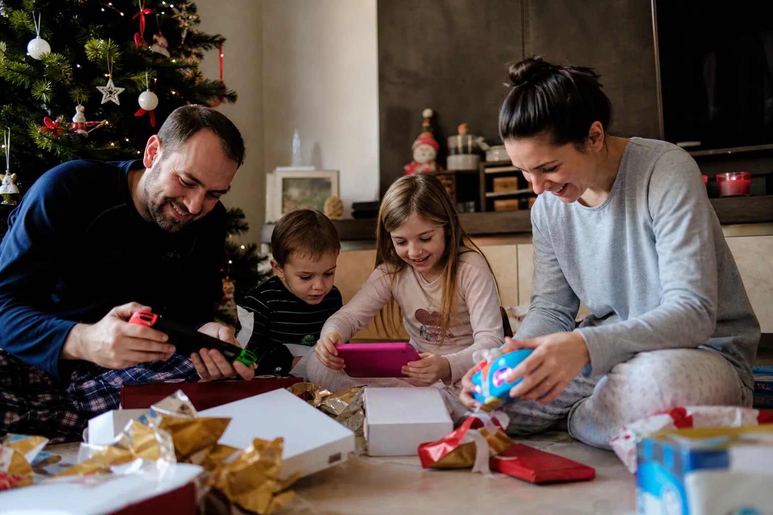 Famille française ouvrant des cadeaux de Noël 2012 dans un salon chaleureux.