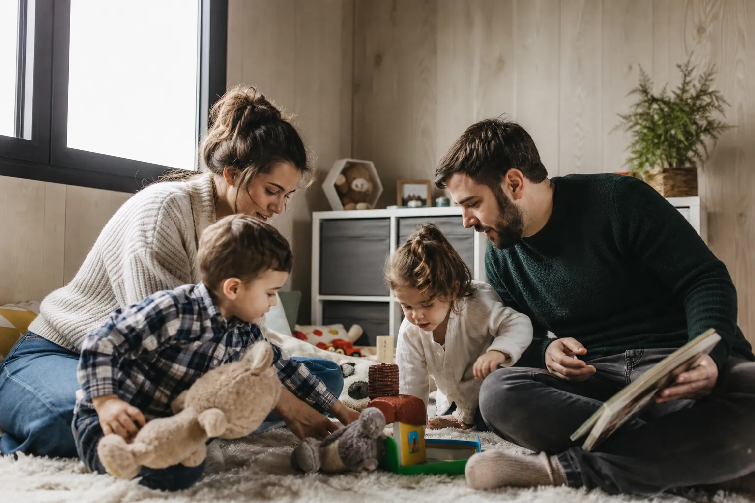 Famille française dans une salle préfabriquée lumineuse, aménagée en salle de jeux pour enfants.