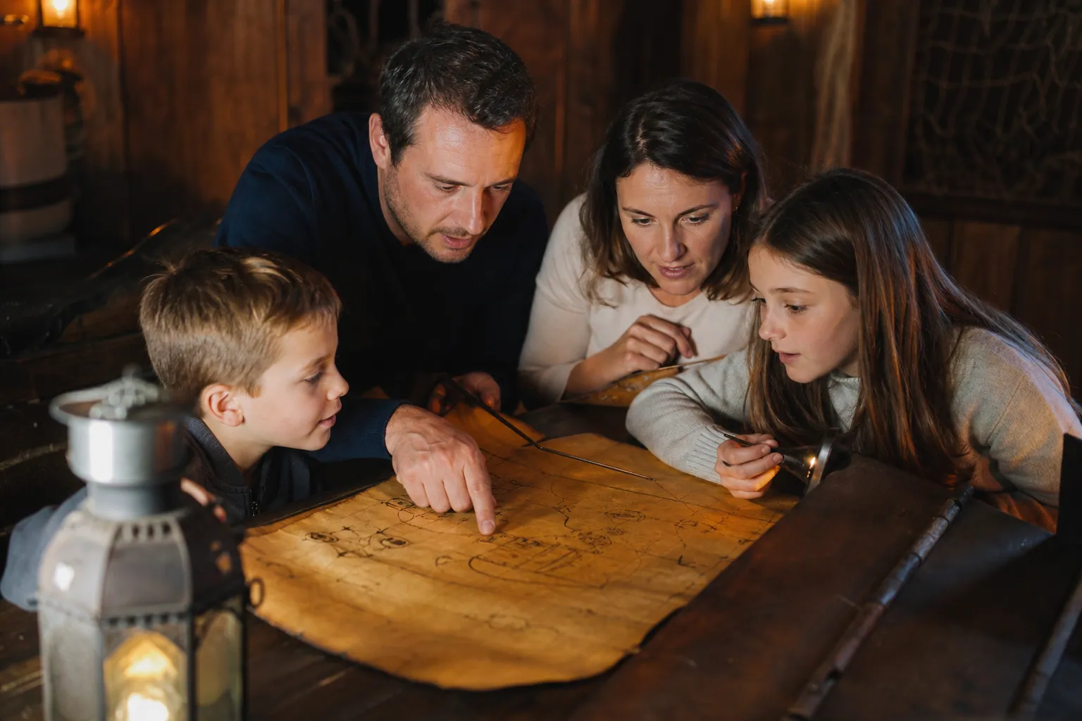Une famille avec deux enfants résout des indices dans un escape game sur le thème des pirates.