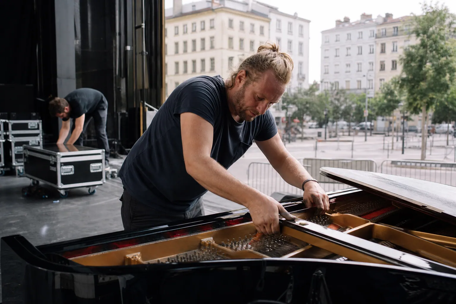 Technicien installant un piano et du backline dans une salle de concert à Lyon.