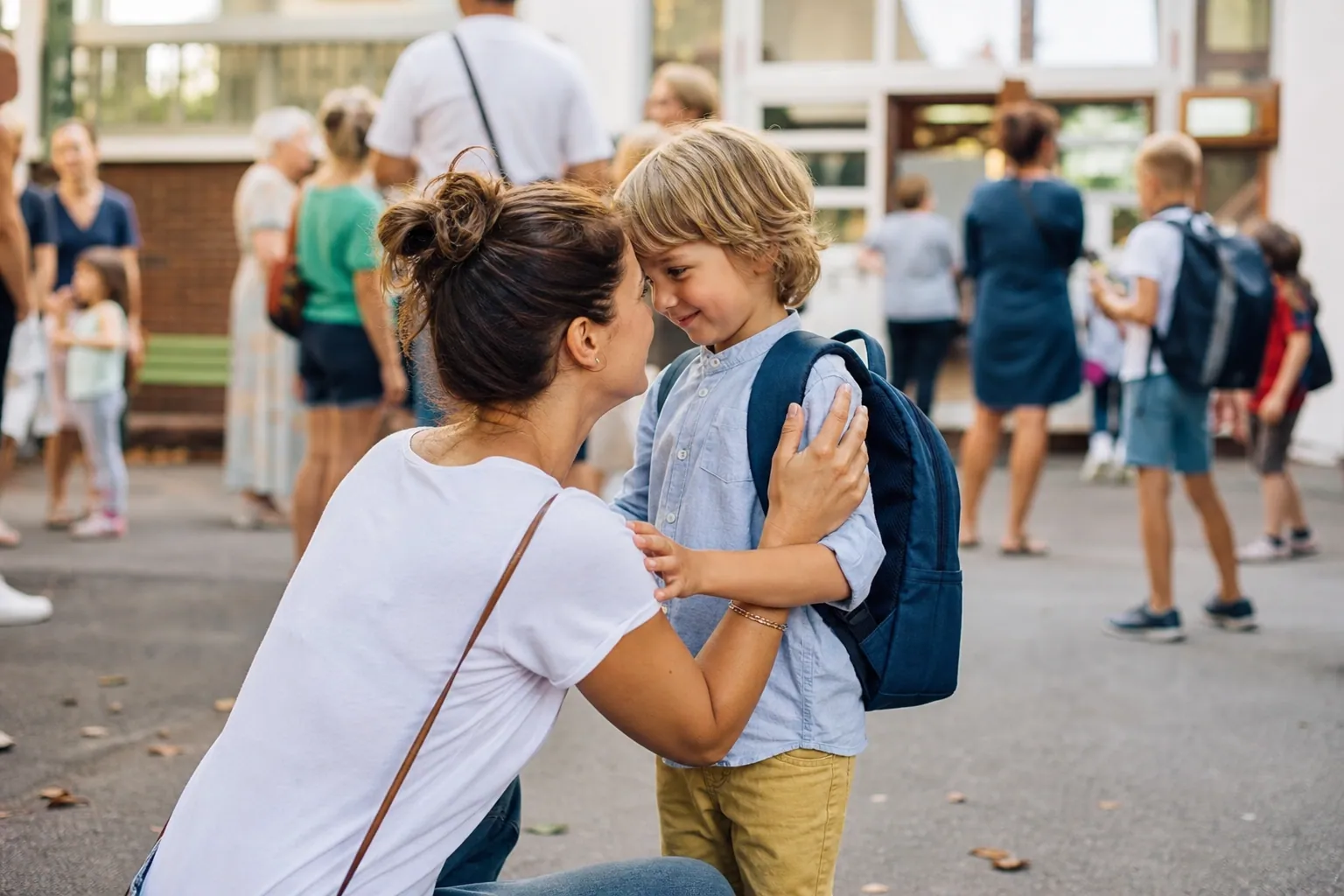 Parent rassurant son enfant devant l’école pour la première rentrée